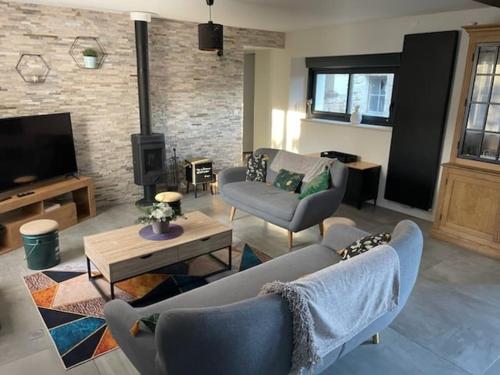 a living room with a couch and chairs and a tv at Belle Maison tourangelle pour 6 personnes in Chambourg-sur-Indre