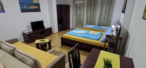 uma sala de estar com duas camas, um sofá e mesas em Center Apartment Delfina em Ohrid