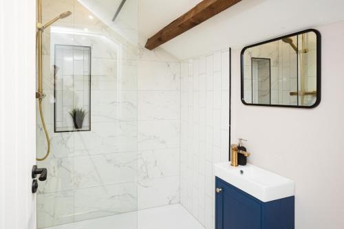 a bathroom with a shower and a blue cabinet at Bankers Room + Kitchenette in Chapel en le Frith