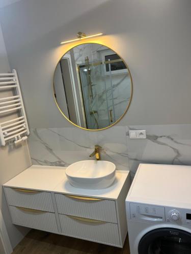 a bathroom with a sink and a mirror at Pokoje u Asi in Augustów
