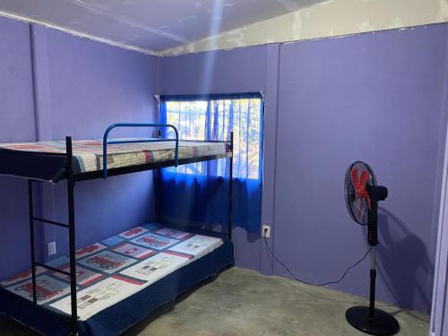 a room with two bunk beds and a fan at Casa Púrpura in La Cruz