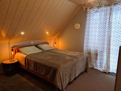 um quarto com uma cama e uma grande janela em WIGWAM Dom z basenem na Kaszubach em Sulęczyno