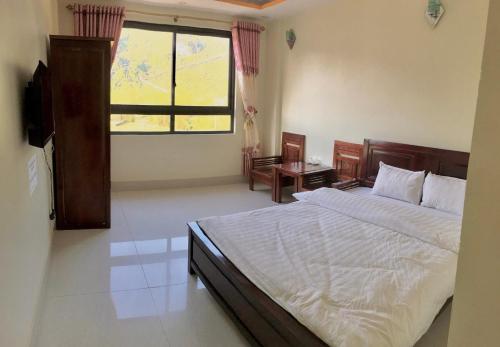 Un dormitorio con una cama grande y una ventana en Khách sạn So Oanh gần thác Bản giốc, en Cao Bằng