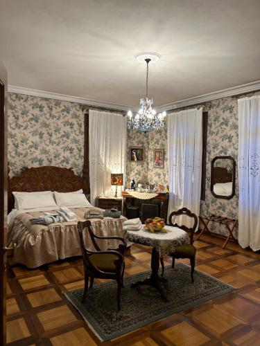 Villa Carla - Camera King Superior في بادوفا: غرفة نوم بسرير وطاولة وكراسي