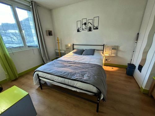 1 dormitorio con 1 cama en una habitación con ventanas en Appartement de 2 chambres avec wifi a Luzenac a 8 km des pistes, en Luzenac