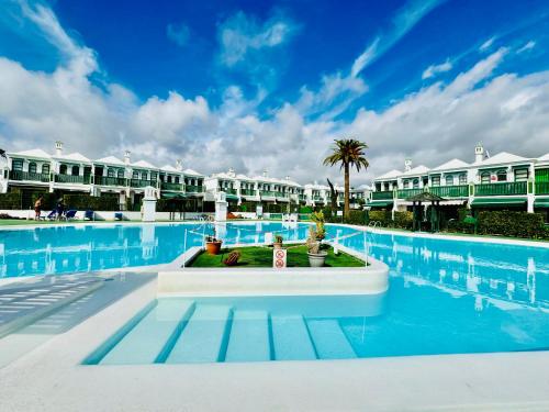 una piscina con acqua blu e edifici bianchi di Casa Dunaflor a Maspalomas