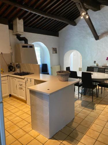 une cuisine avec des armoires blanches et une table et des chaises dans l'établissement MAISON DE CAMPAGNE à GIgnac, à Gignac