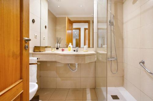 uma casa de banho com um lavatório e um chuveiro em Apartamento Caires no Funchal