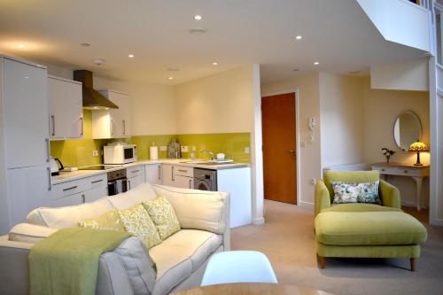 un soggiorno con divano e una cucina di WEE SUZIE STAYS - Stunning George St Apartment a Perth