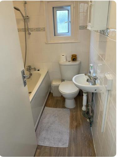 uma casa de banho com um WC, um lavatório e uma banheira em Lovely room in Tottenham em Londres