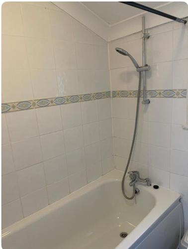 a bathroom with a bath tub with a shower at Lovely room in Tottenham in London