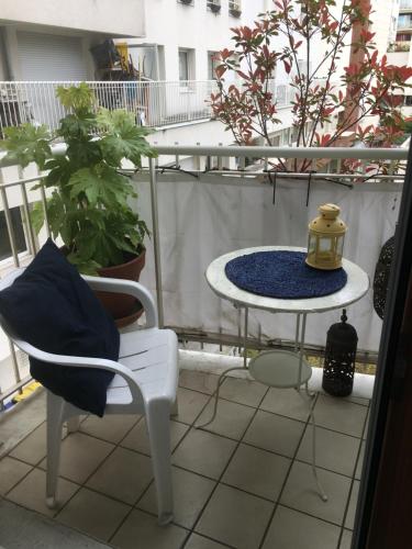 uma varanda com uma mesa e uma cadeira em Chambre avec balcon et salle de bain privée em Paris