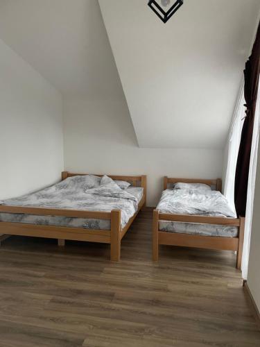 two twin beds in a room with white walls at Woodland Resort Shkrel in Boge