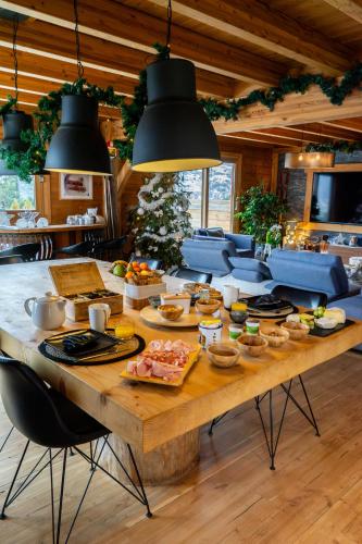 a large wooden table with food on top of it at Chambres et table d'hôtes au chalet Datcha in Briançon