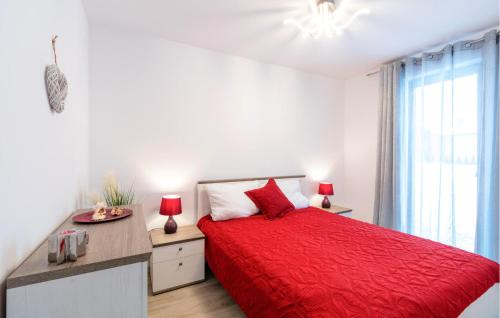 a white bedroom with a red bed and a window at Amazing Apartment In Zarnowska With Kitchen in Żarnowska