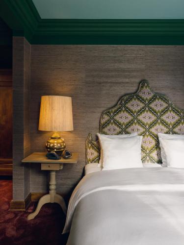 a bedroom with a bed and a lamp on a table at La Butte aux Bois a Small Luxury Hotel of the World in Lanaken