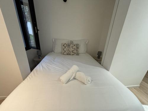 a white bed with two towels on it at Le Repère des Pilotes - Gare - 11p - Rêve au Mans in Écommoy