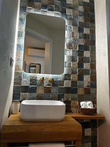 baño con espejo grande y bañera en Mentha Luxury Home, en Lefkogeia