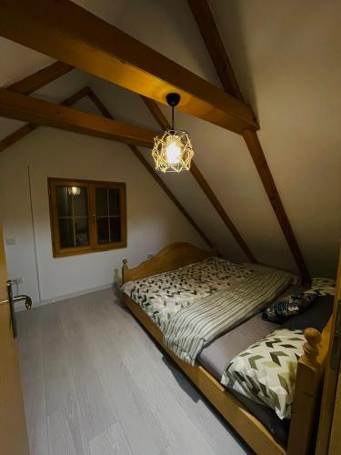 ein Schlafzimmer mit einem Bett im Dachgeschoss mit einem Kronleuchter in der Unterkunft Family cottage Fairy tale in Banja Luka