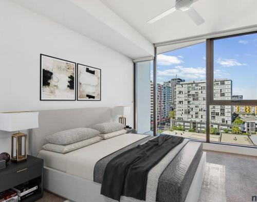 a bedroom with a large bed and a large window at Axle x Apartment in Brisbane