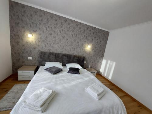 a bedroom with a large white bed with two pillows at Trandafirului Residence Central Suceava in Suceava