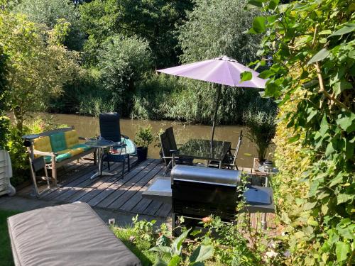 a patio with an umbrella and a table and chairs at Charming Rooms with free parking in Amsterdam