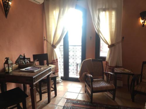 a living room with a table and chairs and a window at Darcilla Guest House in Tarifa