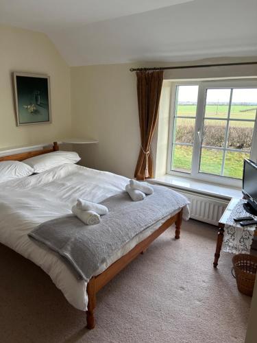 1 dormitorio con 1 cama con 2 toallas en Lucy Cross Guest House en Lucy Cross