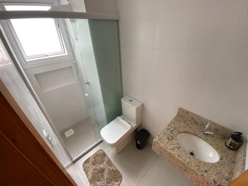 a bathroom with a shower and a toilet and a sink at Ótimo Loft 50m da areia churrasq in Torres