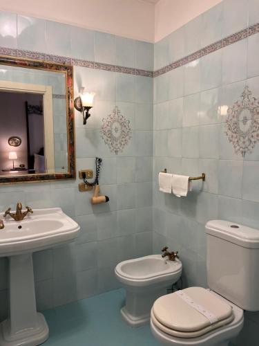 a bathroom with a sink and a toilet and a mirror at Hotel Villa Luppis in Pasiano di Pordenone
