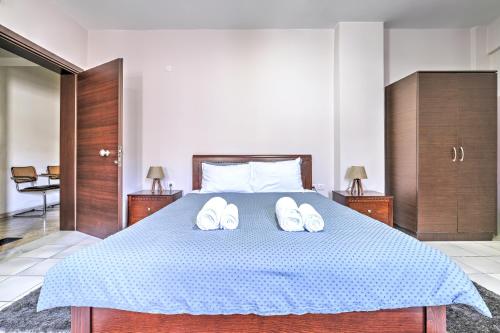 1 dormitorio con 1 cama con 2 pares de zapatillas en Διαμέρισμα στο Κέντρο Ναυπλίου, en Nauplia