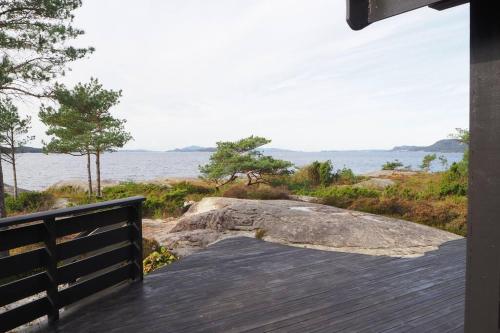 - une terrasse couverte avec vue sur l'eau et un rocher dans l'établissement Magical Seaview and close to Preikestolen, à Strand