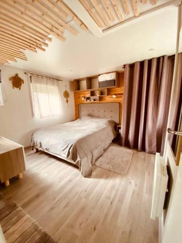 une chambre avec un lit et un parquet dans l'établissement Mobilhome 45m2, à Roquebrune-sur Argens