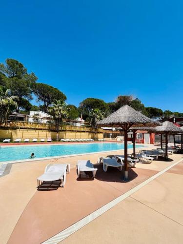 une piscine avec des chaises et des parasols à côté d'une piscine dans l'établissement Mobilhome 45m2, à Roquebrune-sur Argens