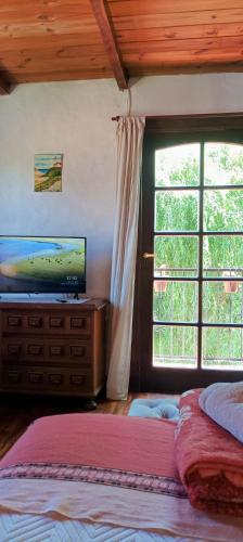 a bedroom with two beds and a large window at Chalet Caserón de Tejas, Amplia y confortable casa para hasta 11 huéspedes in Mar del Plata