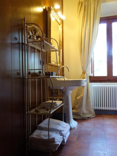 a bathroom with a sink and a shelf with towels at Bella di Ceciliano in Arezzo
