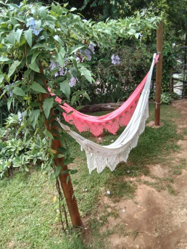 a hammock hanging from a tree in a garden at Pousada Canto Feliz in Serra do Cipo