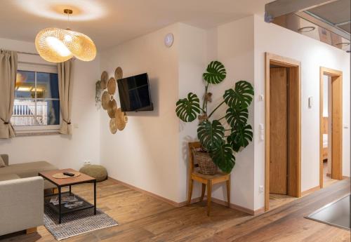 - un salon avec un canapé et une plante sur le mur dans l'établissement Villa Elisabeth, à Strobl