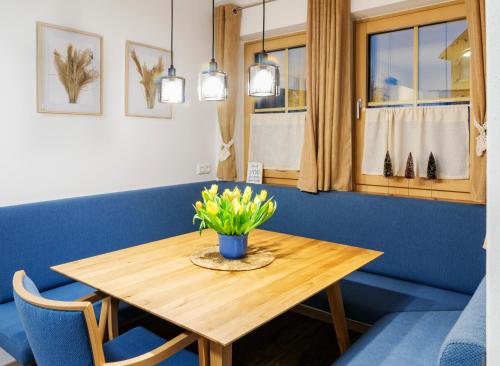 a wooden table with a vase of flowers on it at Villa Elisabeth in Strobl