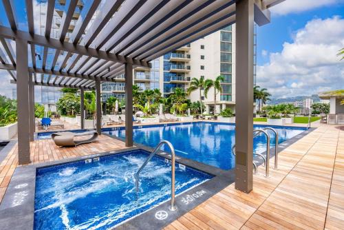 a swimming pool with a pergola next to a building at Sky Ala Moana 4209 condo in Honolulu