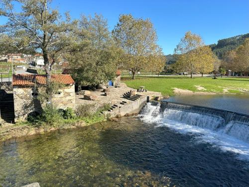 a river with a waterfall in a park at Casa Brandao in Vale de Cambra