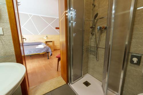 ein Bad mit Dusche und ein Schlafzimmer in der Unterkunft Hotel Park Oasi in Arta Terme