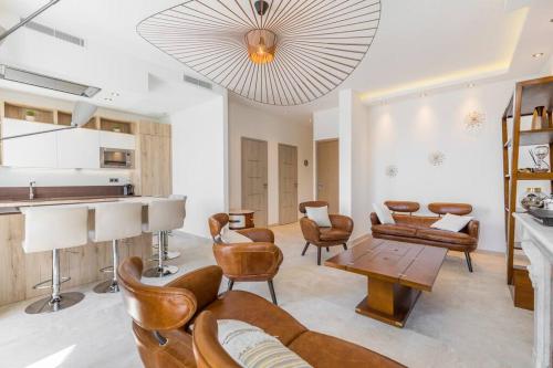 - un salon avec des fauteuils en cuir et une table dans l'établissement Wow this view! 2BR facing Old Port 4th floor Olam Properties, à Cannes