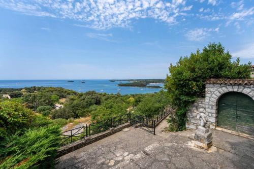 a stone building with a gate and the ocean at Pinna by Briskva in Vrsar