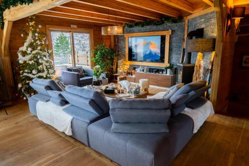 a living room with a large couch and a table at Chambres et table d'hôtes au chalet Datcha in Briançon
