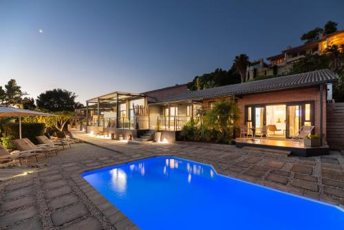 a swimming pool in front of a house at THEBLOEM Guest Suites by Knysna Paradise Collection in Knysna
