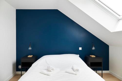 a bedroom with a blue wall and a white bed at Le Grand Bleu - Wifi fibre/Linge/Accès cour in Saint-Mars-la-Jaille