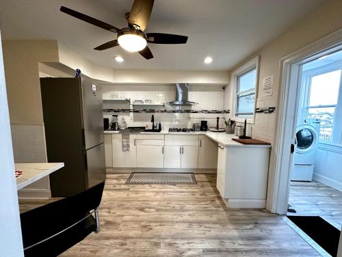 a kitchen with white cabinets and a ceiling fan at 2-A Diamond in Yonkers in Yonkers