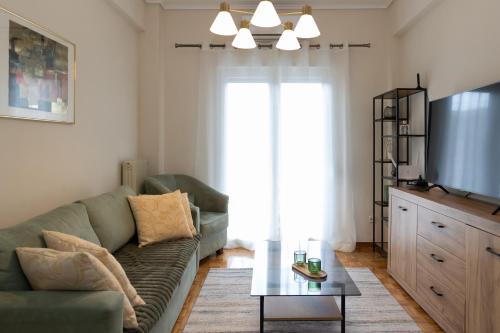 een woonkamer met een groene bank en een tv bij Santa Marina 2 in Ioannina