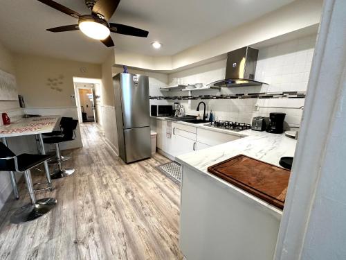 a large kitchen with white cabinets and stainless steel appliances at 2-A Diamond in Yonkers in Yonkers